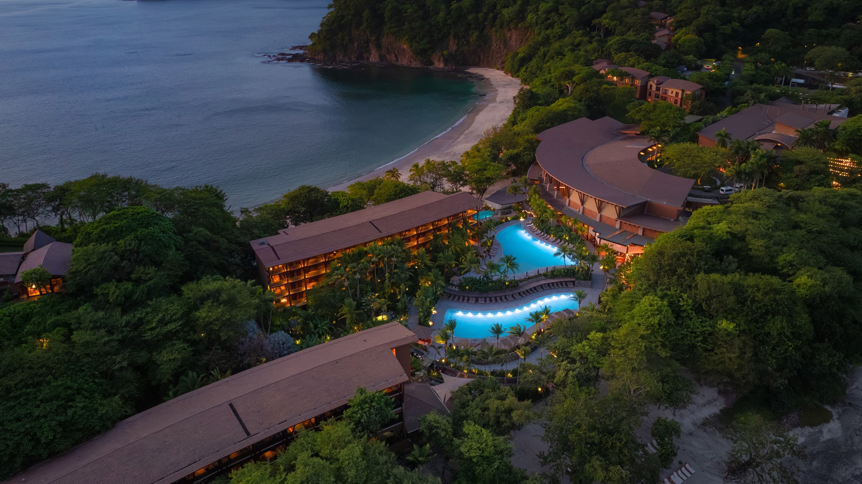 Resort buildings and pools above the beach at dusk