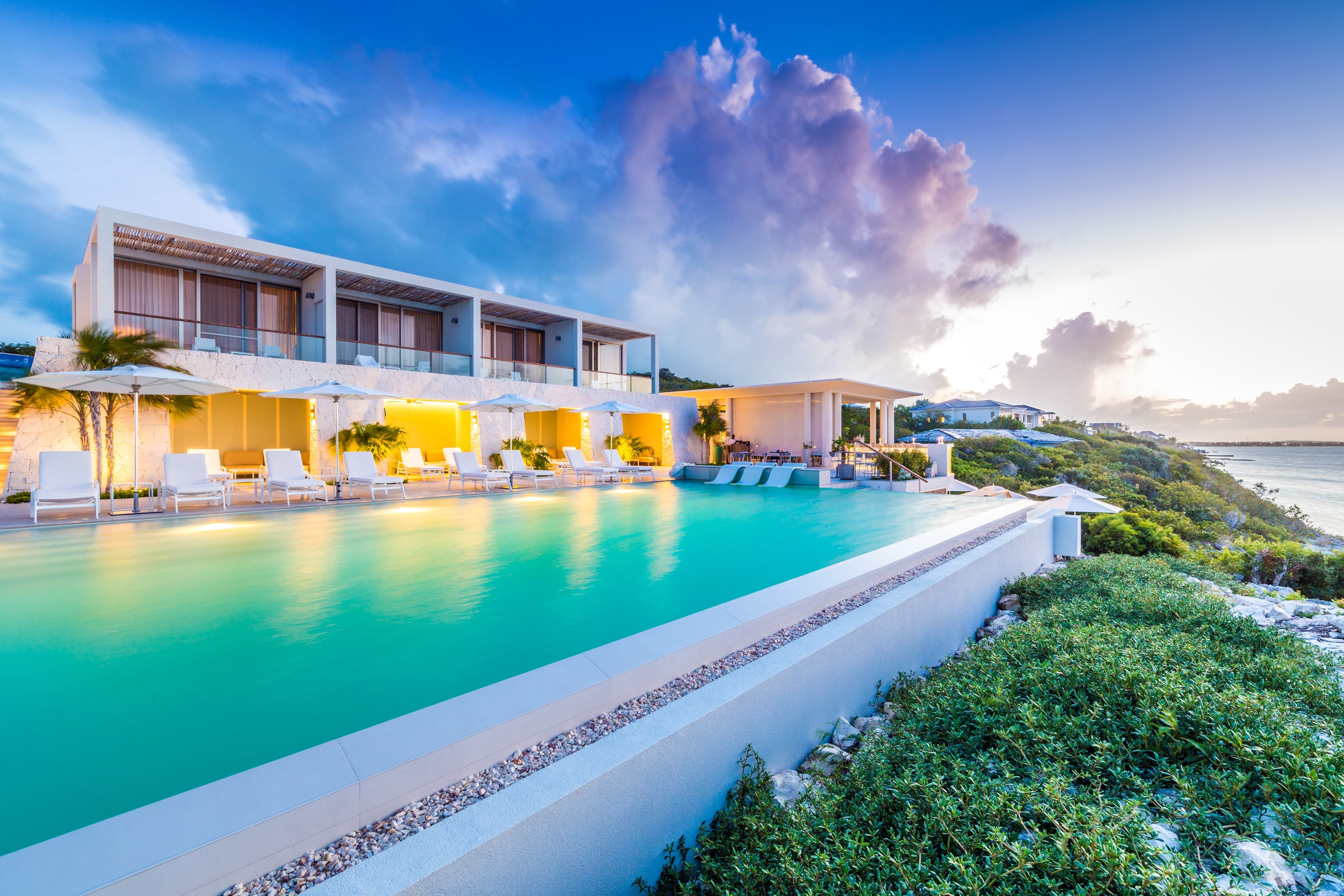 Cliff-top pool and resort building at dusk